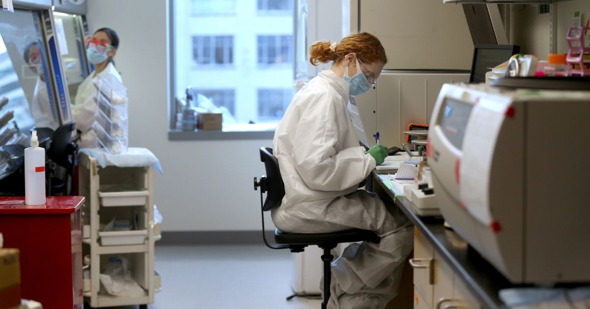 Research scientists work on the development of a replicon, or replicating, RNA vaccine, used to combat COVID-19, at a microbiology lab at the University of Washington School of Medicine on Dec. 10, 2020, in Seattle.