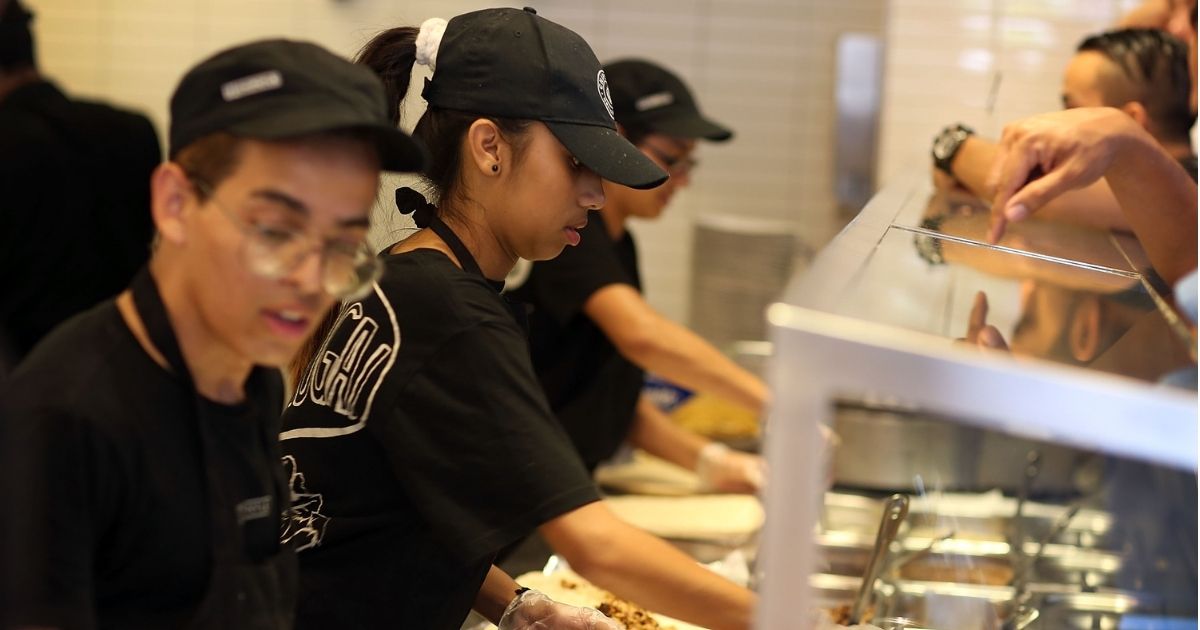 Chipotle restaurant workers fill orders for customers on April 27, 2015, in Miami.