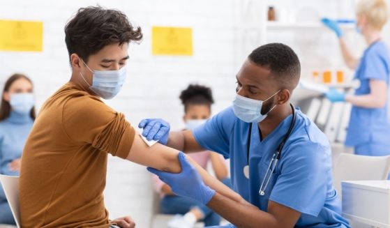 The above stock photo shows a young man getting the coronavirus vaccine.