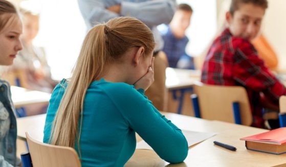 A student is pictured crying in class in the stock image above.