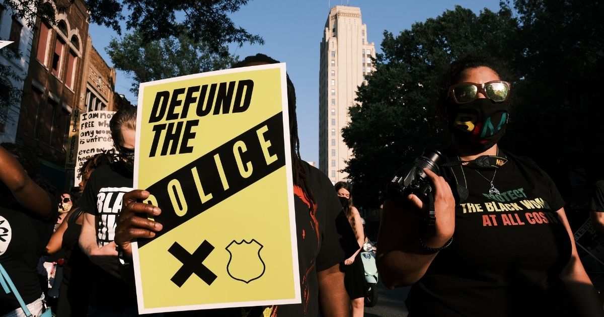 A protester carries a sign that reads "Defund the Police" during a Black Lives Matter demonstration in Richmond, Virginia, on July 3, 2020.
