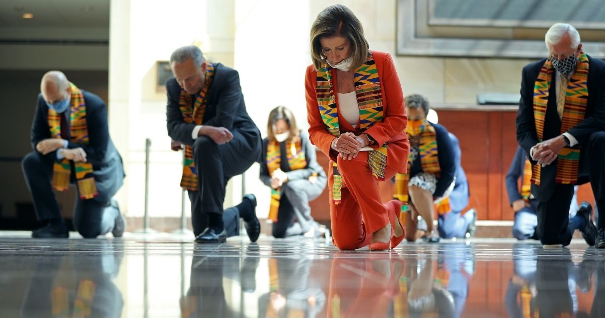 Then-Senate Minority Leader Chuck Schumer, House Speaker Nancy Pelosi and other Democrats kneel for eight minutes and 46 seconds to honor George Floyd in the U.S. Capitol Visitors Center in Washington on June 8, 2020.