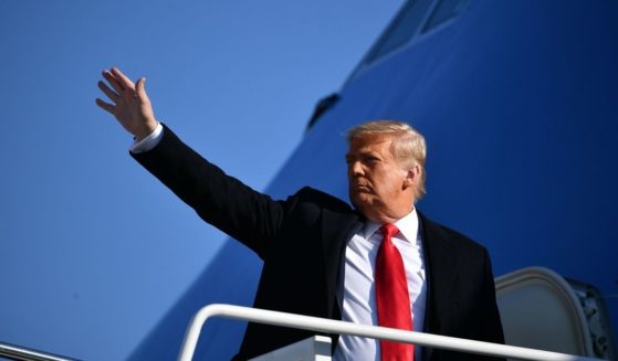Then-President Donald Trump waves to the media as he makes his way to board Air Force One before departing from Andrews Air Force Base in Maryland on January 12.