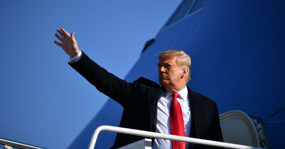 Then-President Donald Trump waves to the media as he makes his way to board Air Force One before departing from Andrews Air Force Base in Maryland on January 12.