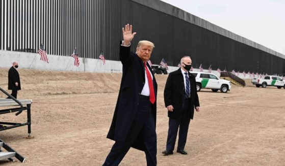 President Donald Trump waves after speaking and touring a section of the border wall in Alamo, Texas, on Jan. 12, 2021.