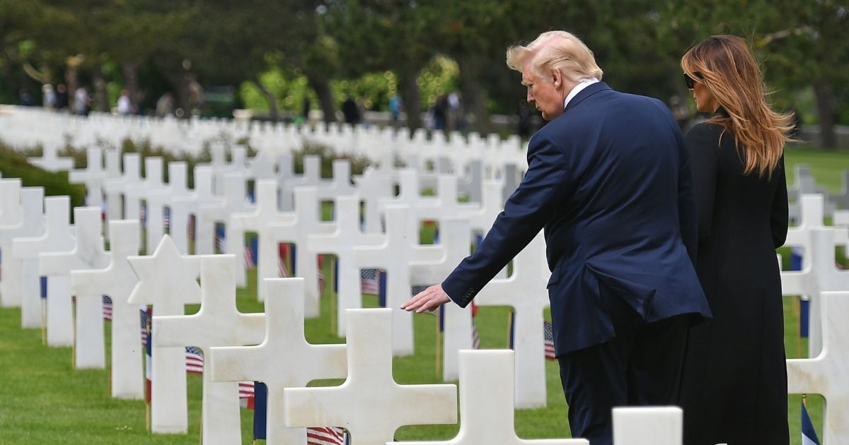 Then-President Donald Trump, left, and then-first lady Melania Trump visit graves after a French-U.S. ceremony at the Normandy American Cemetery and Memorial in Colleville-sur-Mer, Normandy, northwestern France, on June 6, 2019.
