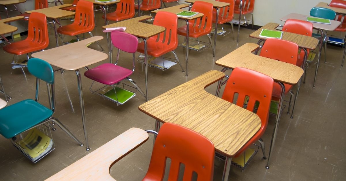 An empty school classroom is seen in the stock image above.
