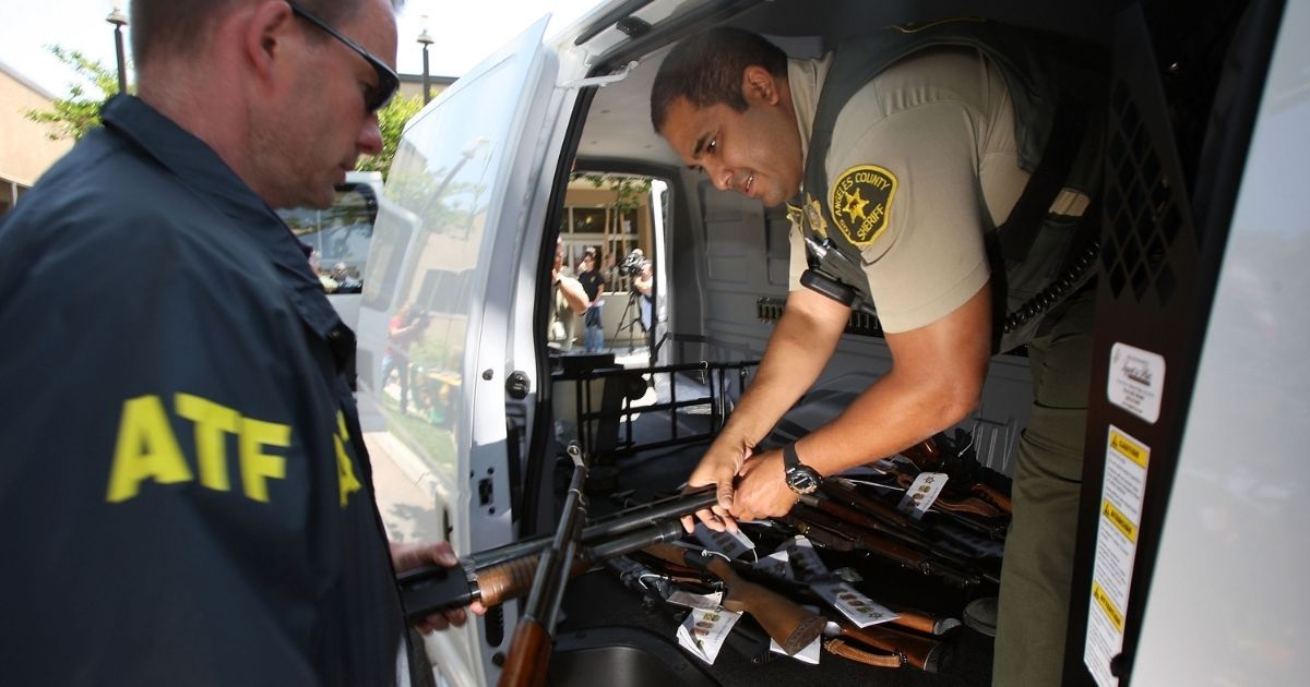 Officers begin to load confiscated weapons into a van on May 21, 2009, in the Los Angeles-area community of Lakewood, California.
