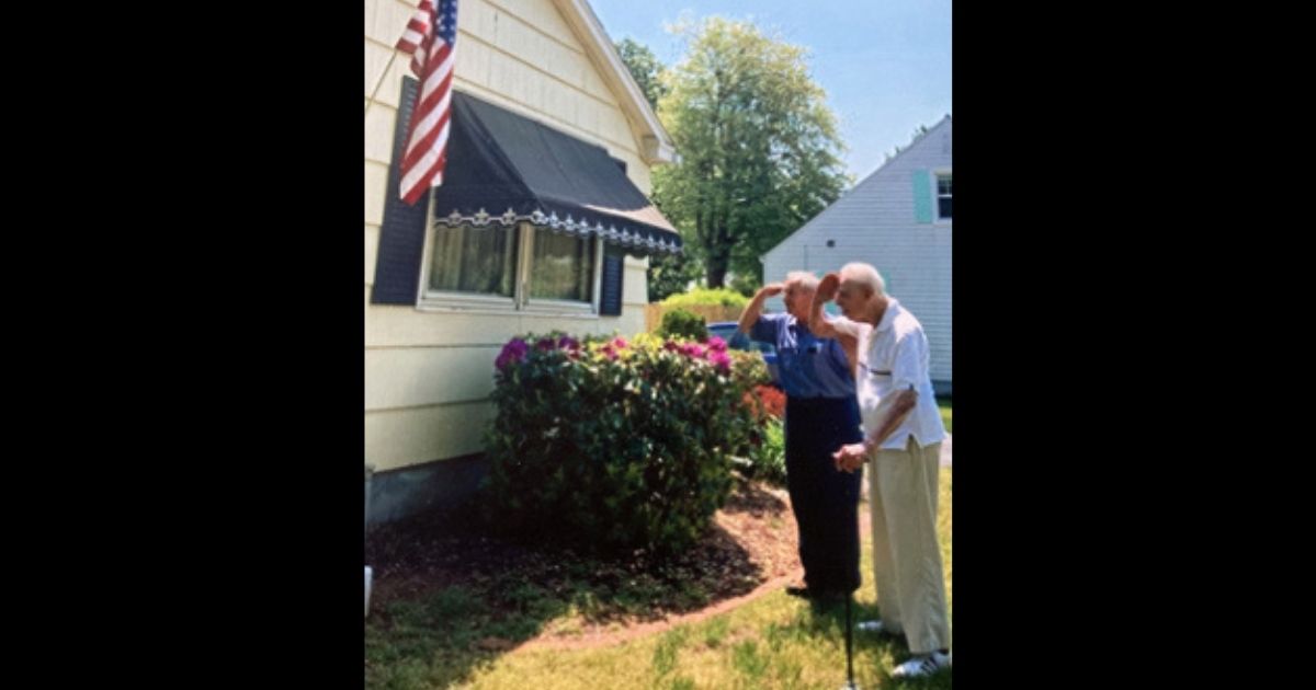 Jack Henrique of Hampden County, Massachusetts, salutes the flag alongside his 100-year-old neighbor, Mario Arcobello.