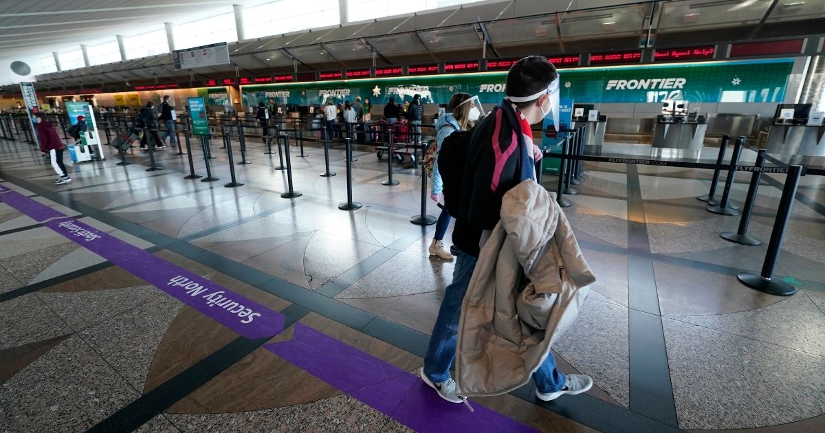 Travelers walk past the Frontier Airlines ticketing counter in the main terminal of Denver International Airport on Dec. 31.