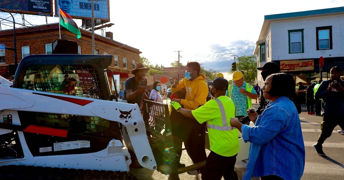 Residents try to stop a loader Thursday morning in Minneapolis as the city ordered George Floyd Square to be cleared for traffic.