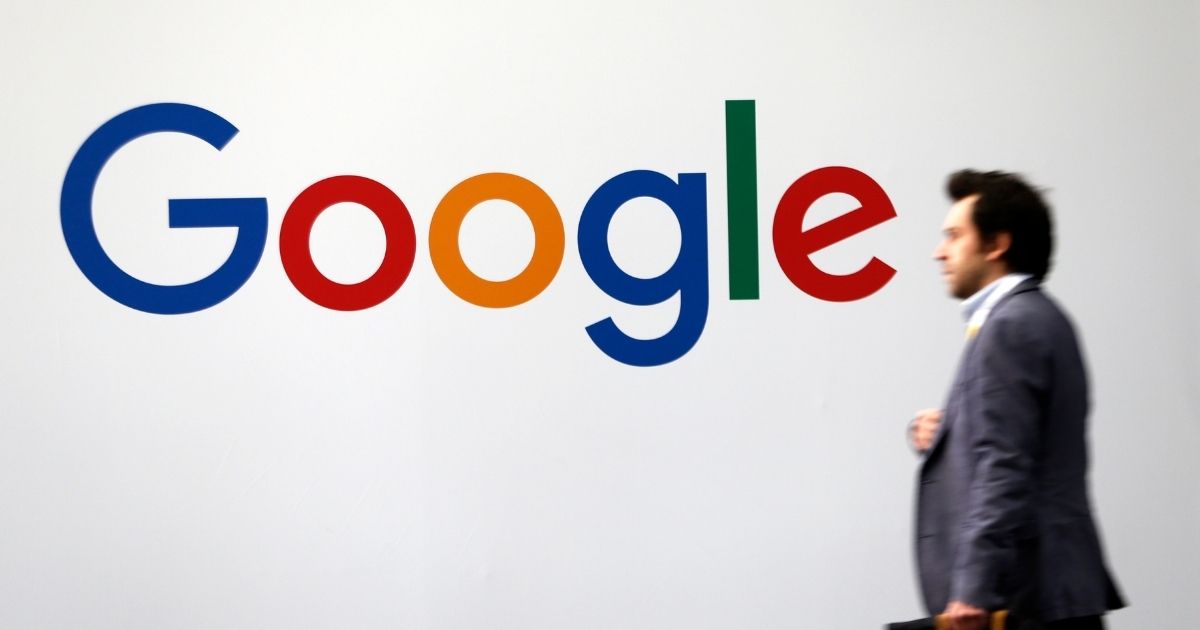 A man passes by the logo of Google on May 16, 2019, in Paris.