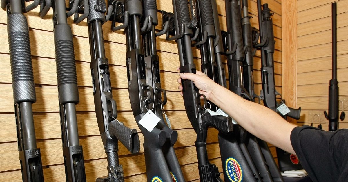 A sales associate takes a gun from a display of shotguns at The Gun Store on Nov. 14, 2008, in Las Vegas.