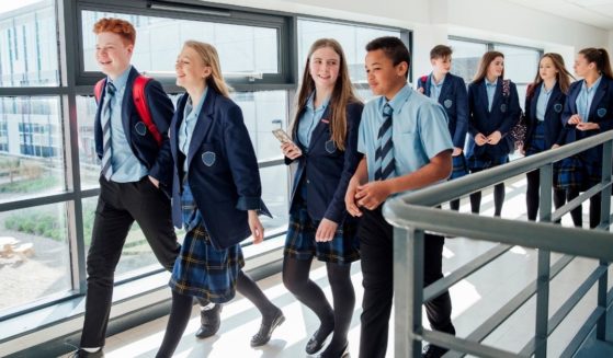 High school students are pictured walking to class in the stock image above.
