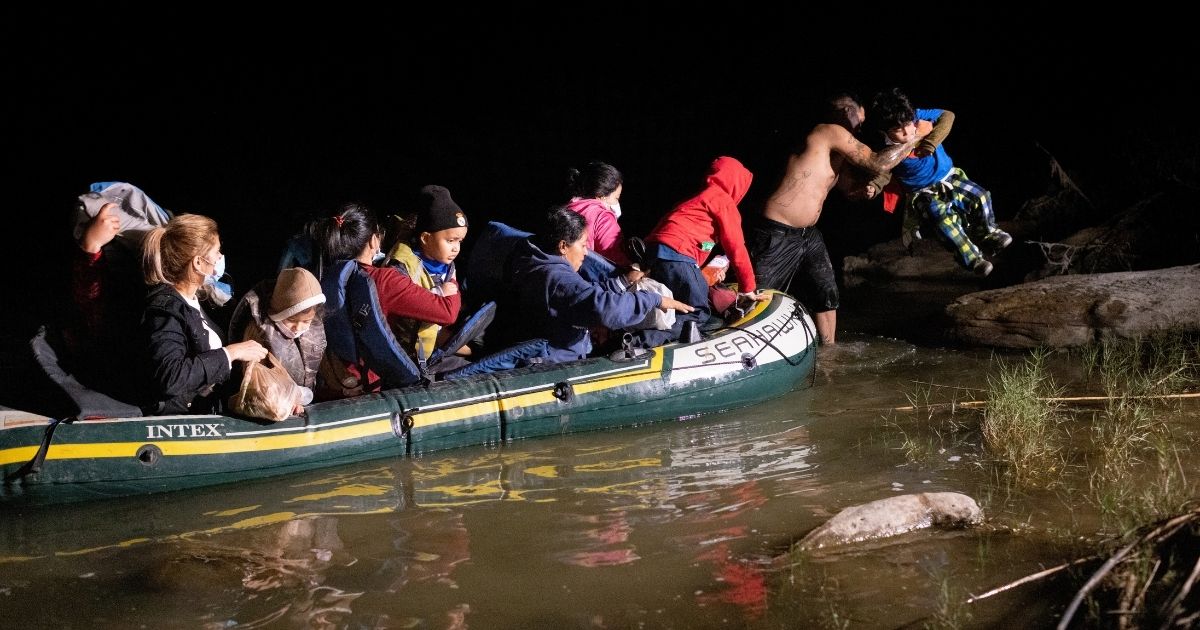 A smuggler lifts an immigrant child on to the bank of the Rio Grande after illegally crossing the U.S.-Mexico border near Roma, Texas, early on April 30.
