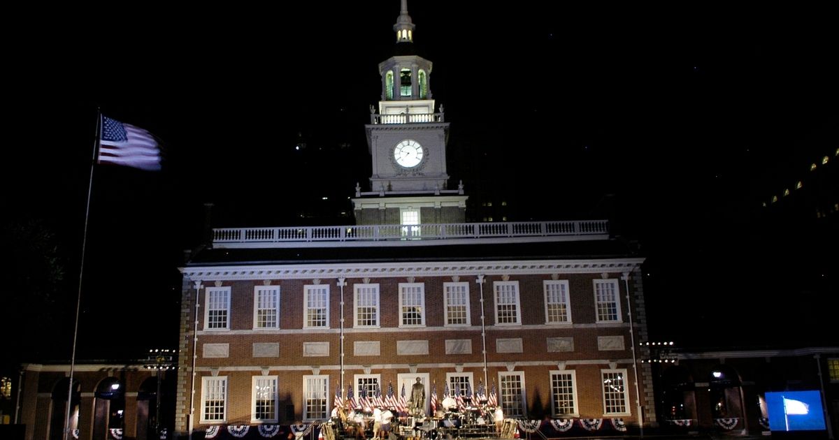 An American flag flies over the building after the re-lighting of Independence Hall on July 3, 2005, in Philadelphia.