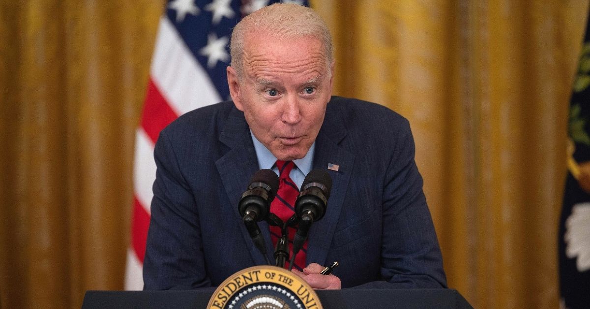 President Joe Biden leans forward and speaks softly during an address in the East Room of the White House in Washington on Thursday.