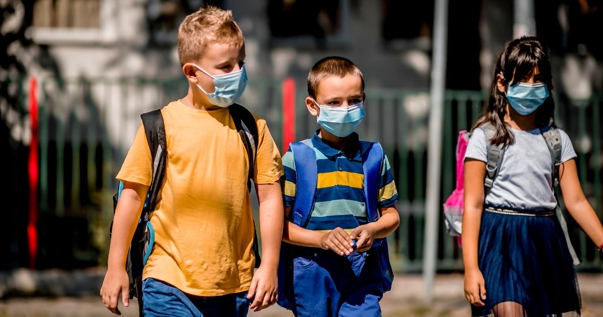 Children wear masks as they go to school.
