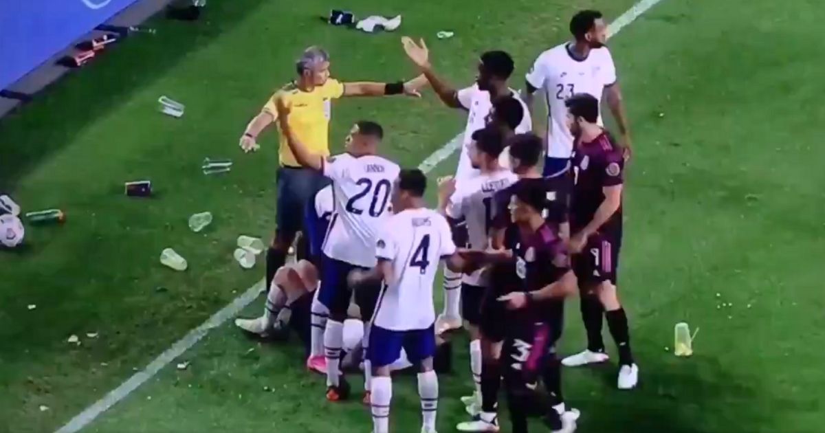 Members of the U.S. team react to objects being thrown by Mexican fans after their 3-2 win.