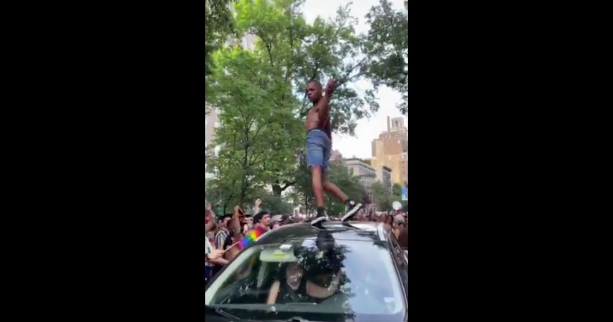In a video shared on Twitter on Monday, a Pride March celebrator jumps on a moving vehicle and dances provocatively on it