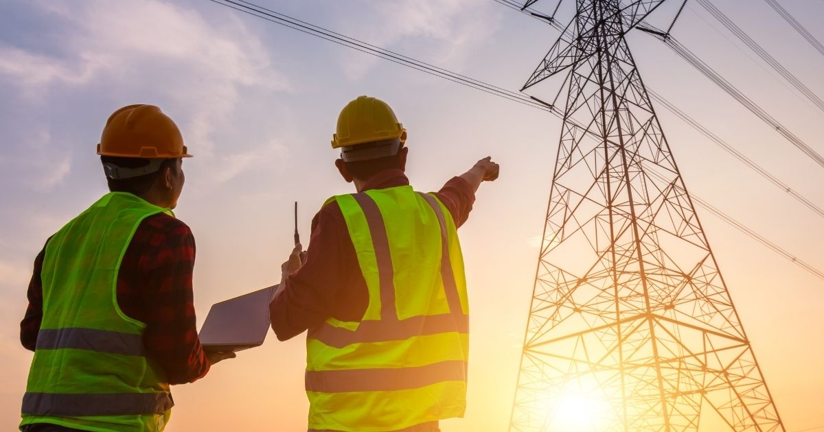 The above stock photo shows two workers inspecting the electricity high-voltage pole.