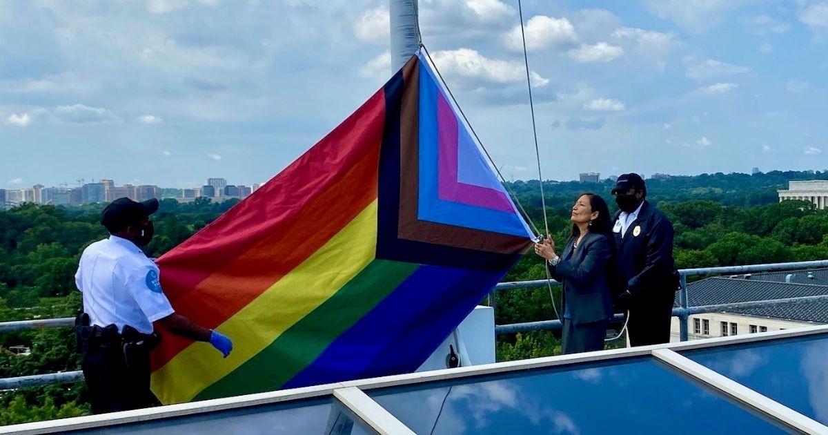 Interior Secretary Deb Haaland raises the "Progress Pride" flag above her department's headquarters in Washington, D.C.