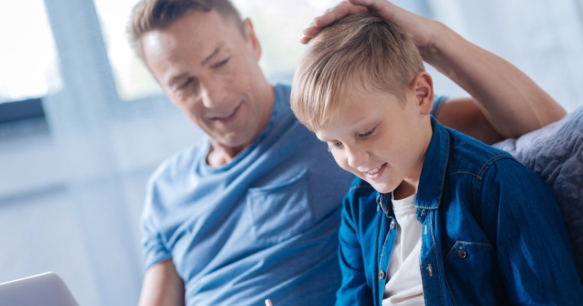 A proud father is seen patting his son on the head in the stock image above.