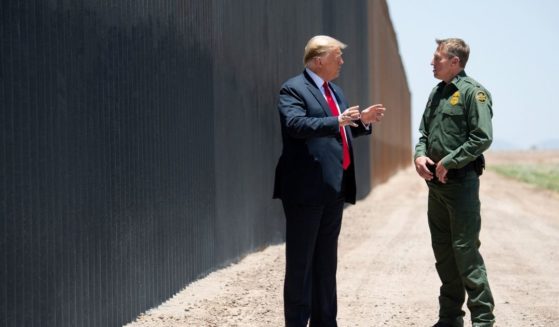 President Donald Trump speaks with Border Patrol Chief Rodney Scott, right, as they participate in a ceremony commemorating the 200th mile of border wall at the U.S.-Mexico border in San Luis, Arizona, on June 23, 2020.