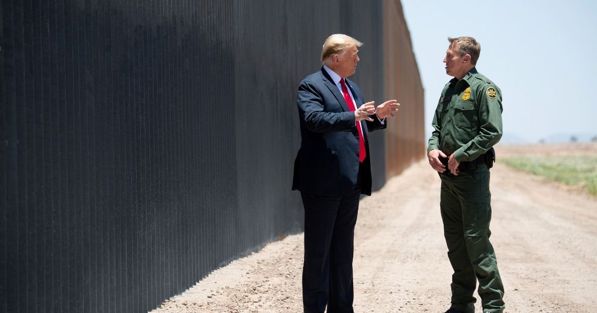 President Donald Trump speaks with Border Patrol Chief Rodney Scott, right, as they participate in a ceremony commemorating the 200th mile of border wall at the U.S.-Mexico border in San Luis, Arizona, on June 23, 2020.