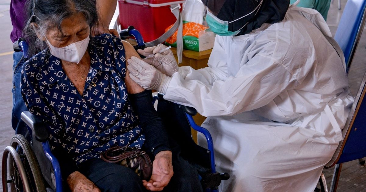 An elderly woman receives the Sinovac coronavirus vaccine at a sports facility in Banda Aceh, Indonesia, on Wednesday.