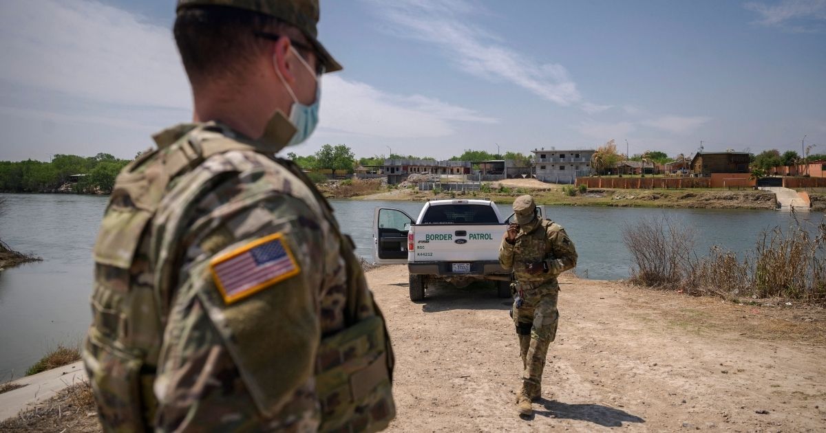 Border Patrol agents are pictured standing in front of the Rio Grande and a suburb of the Mexican city of Ciudad Miguel Aleman in the southern Texas border city of Roma.