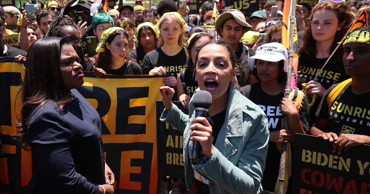 Democratic Rep. Cori Bush of Missouri, left, and Democratic Rep. Alexandria Ocasio-Cortez of New York rally hundreds of young climate activists in Lafayette Square on the north side of the White House to demand that President Joe Biden work to make the Green New Deal into law on Monday in Washington, D.C.