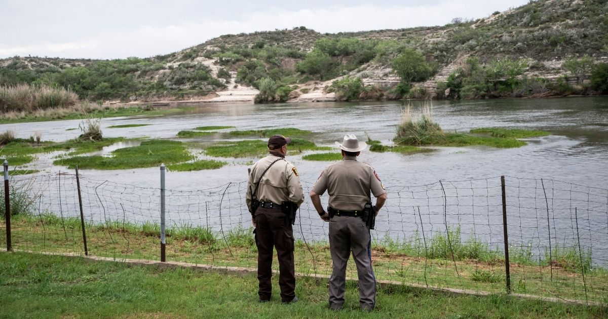 Officers look out at the Rio Grande between Mexico and the United States in Del Rio, Texas, on May 16, 2021.
