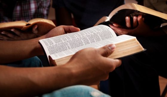 This stock photo portrays a group of young adults reading their Bibles together. Black theologian Voddie T. Baucham, an American-born pastor who now lives in Zambia, discusses what the Bible has to say about racism.