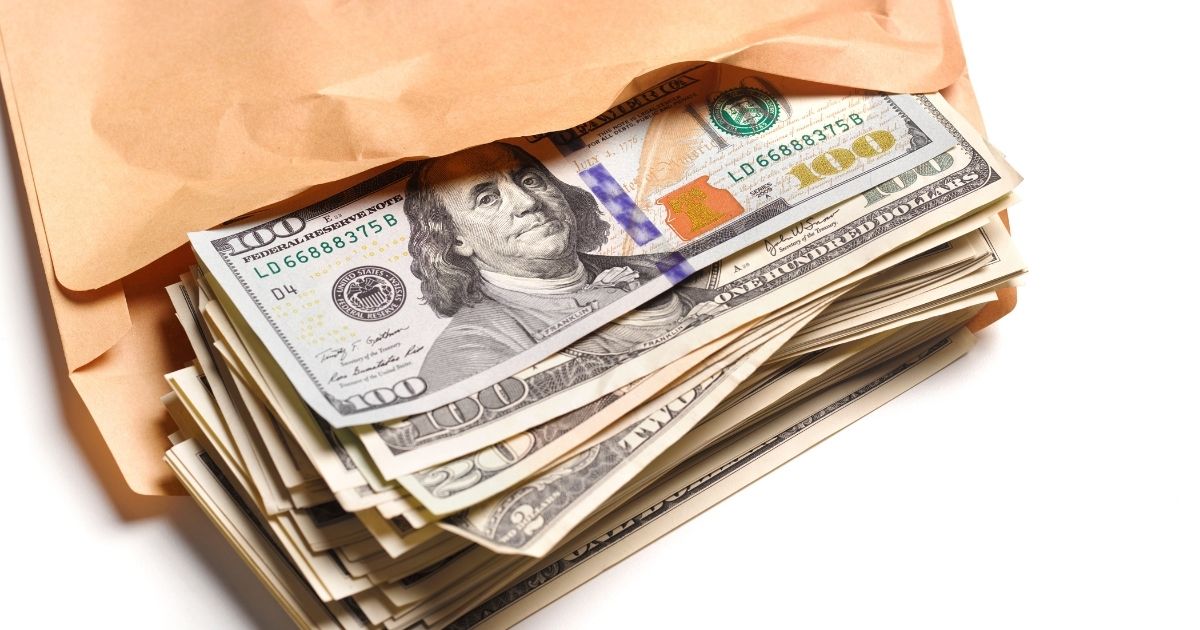 This stock image portrays an envelope full of cash. One study is now suggesting that families can receive up to six figures from the federal government while on unemployment.