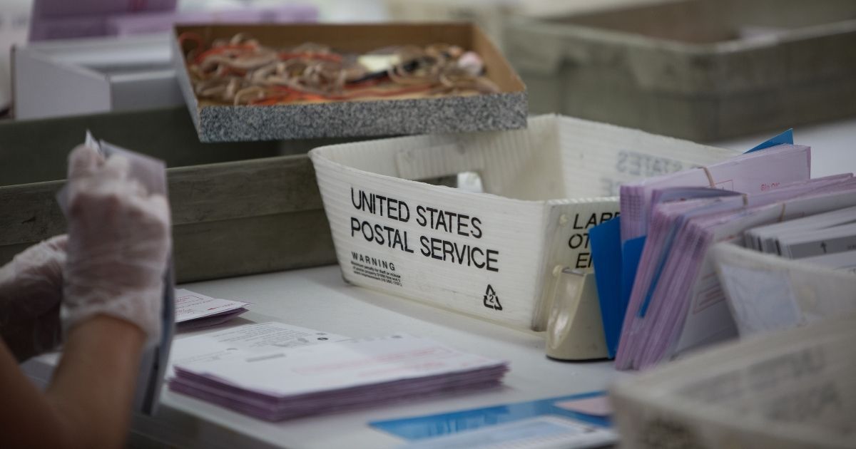 Election poll workers count vote-by-mail ballots from United States Postal Service boxes during Nevada's June 2020 primary election.