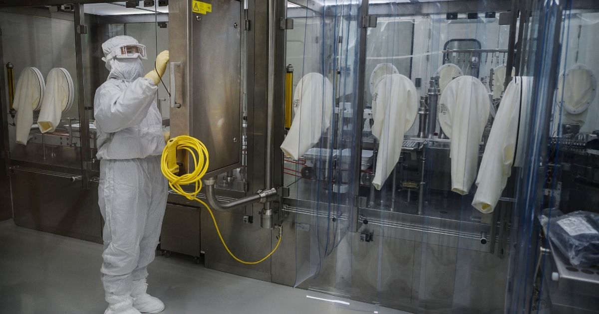 A worker in protective gear is pictured in a Beijing plant where the Sinovac Biotech firm is producing a vaccine against COVID-19 made from an inactivated form of the coronavirus.