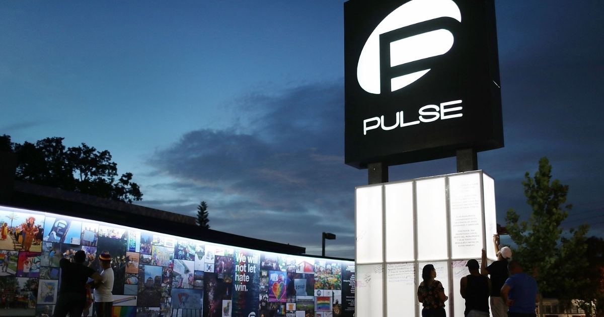 People on June 11, 2018, visit the memorial set up for the 49 patrons who were killed at the Pulse Nightclub in Orlando, Florida, two years earlier.