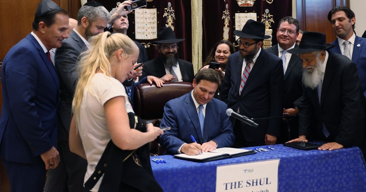Florida Gov. Ron DeSantis signs a bill at The Shul of Bal Harbour on June 14, 2021, in Surfside, Florida. The bills, HB 529, requires Florida schools to hold a daily moment of silence.