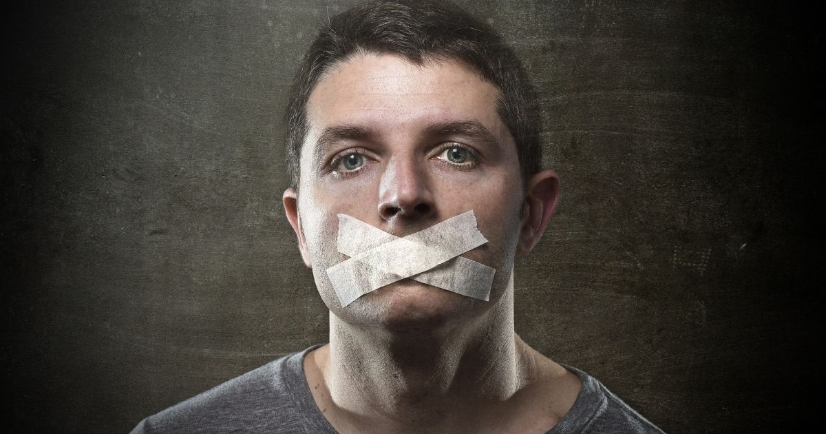A man with tape in an "X" shape over his mouth.