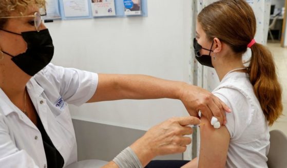 A 14-year-old girl receives a dose of the Pfizer COVID-19 vaccine in Tel Aviv, Israel, on June 6, 2021. Through June, Colorado will give 25 college scholarships worth $50,000 apiece to 12- to 17-year-olds who have received at least one dose of an approved coronavirus vaccine.