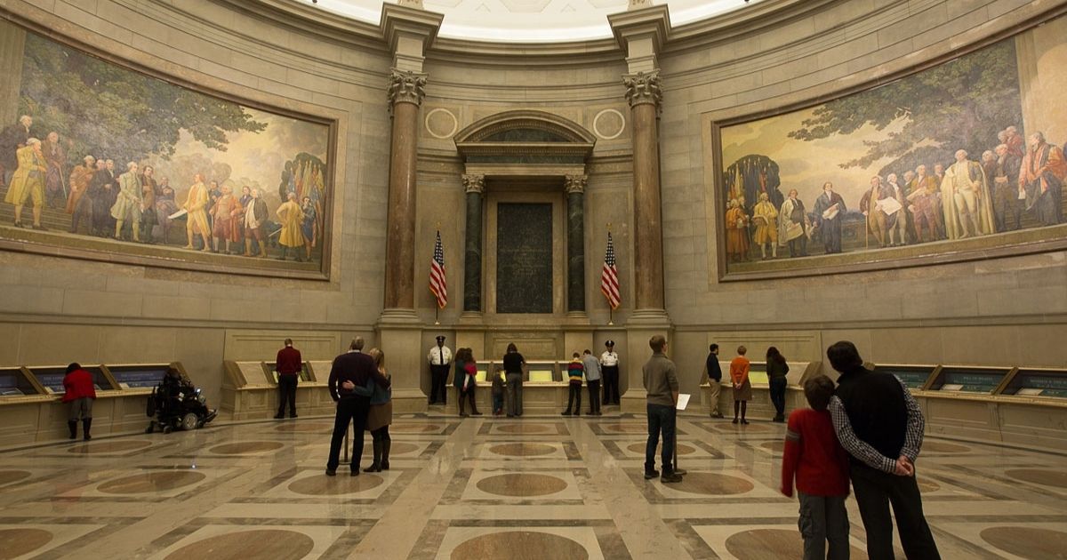Visitors in the National Archives Rotunda take in murals celebrating the nation's founding.