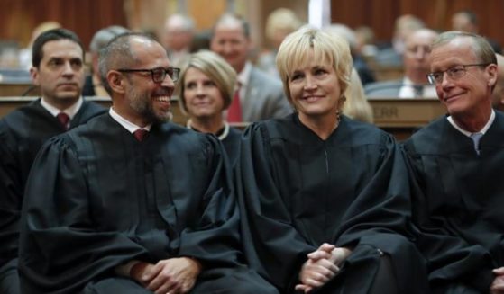 In this Jan. 14, 2020 file photo, Iowa Supreme Court Justices Christopher McDonald, left, Susan Christensen, center, and Edward Mansfield, right, attend Iowa Gov. Kim Reynolds' Condition of the State address at the Statehouse in Des Moines, Iowa.
