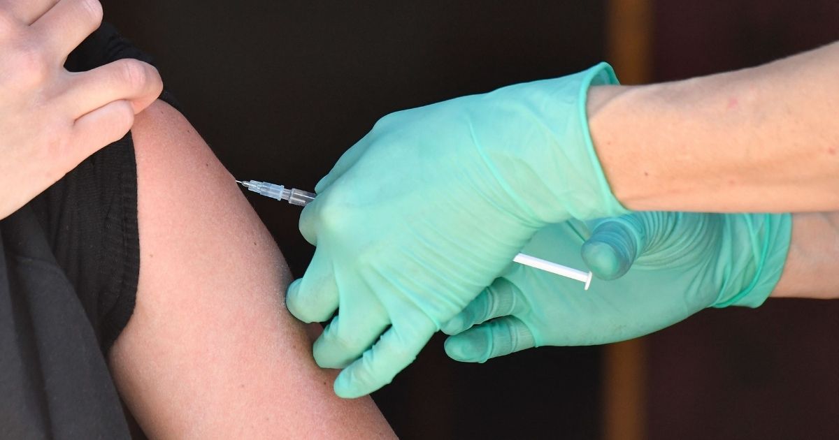 A medical assistant inserts into the arm the needle of a syringe containing the Johnson & Johnson COVID-19 vaccine at the Revolte Bar pub in Berlins Friedrichshain district in Germany on May 30.