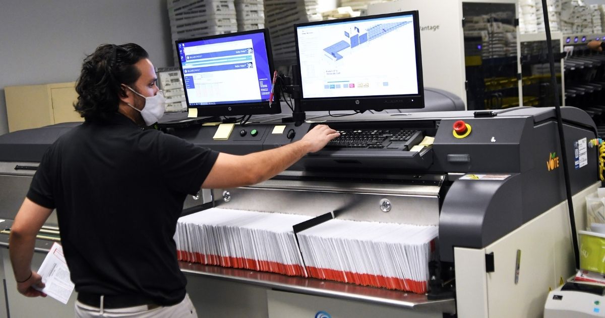 Bruno Morini loads mail-in ballots into a sorting machine at the Orange County Supervisor of Elections office in Orlando, Florida, on Oct. 26.