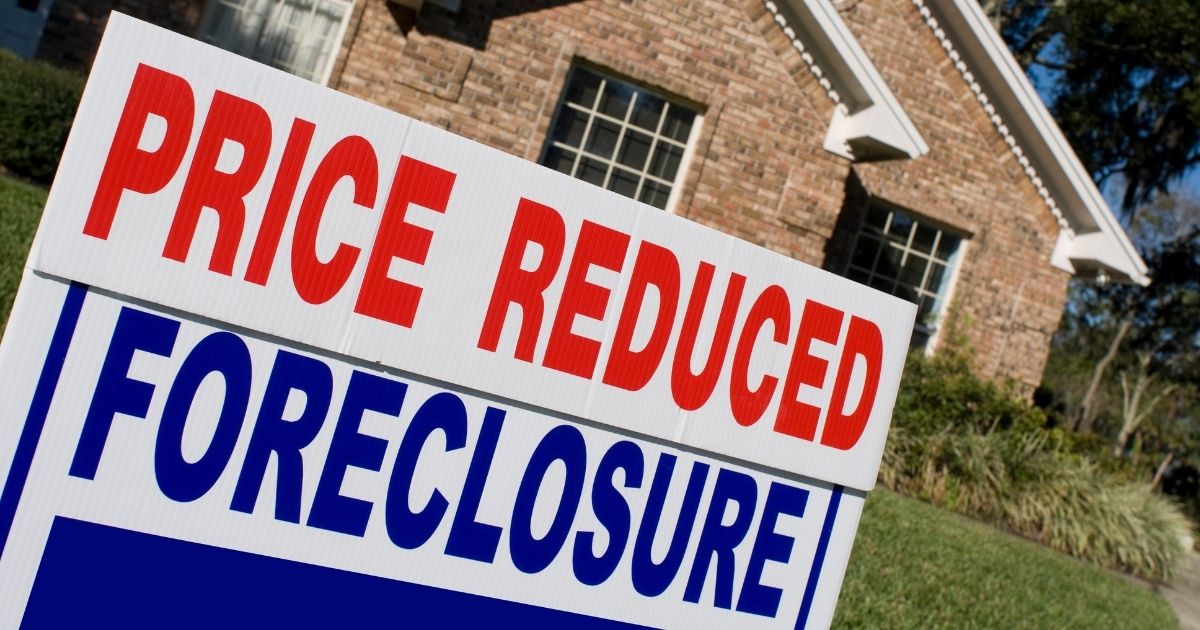 A foreclosure sign appears in front of a house in the above stock image.
