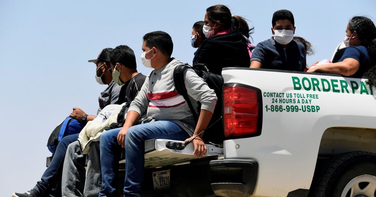 Migrants attempting to cross into the U.S. from Mexico are detained by U.S. Customs and Border Protection on May 21, 2021, in San Luis, Arizona.