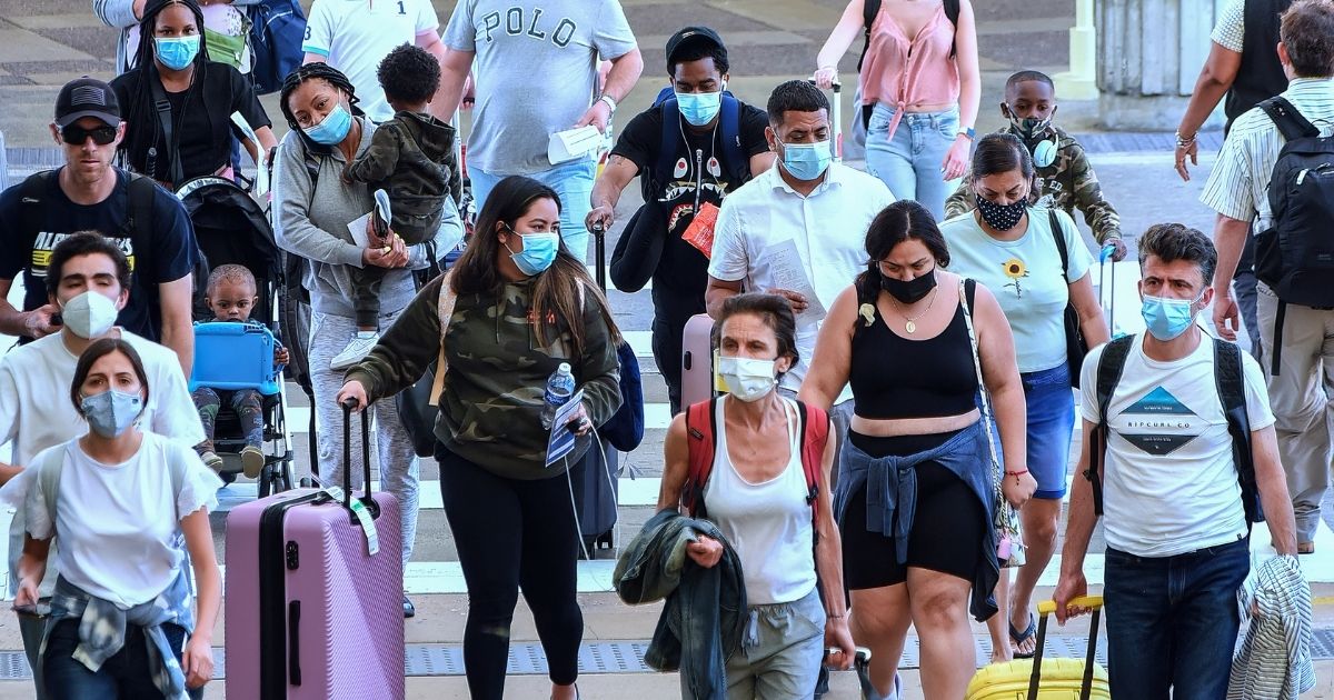 Travelers wearing masks arrive at Orlando International Airport on May 28, 2021.