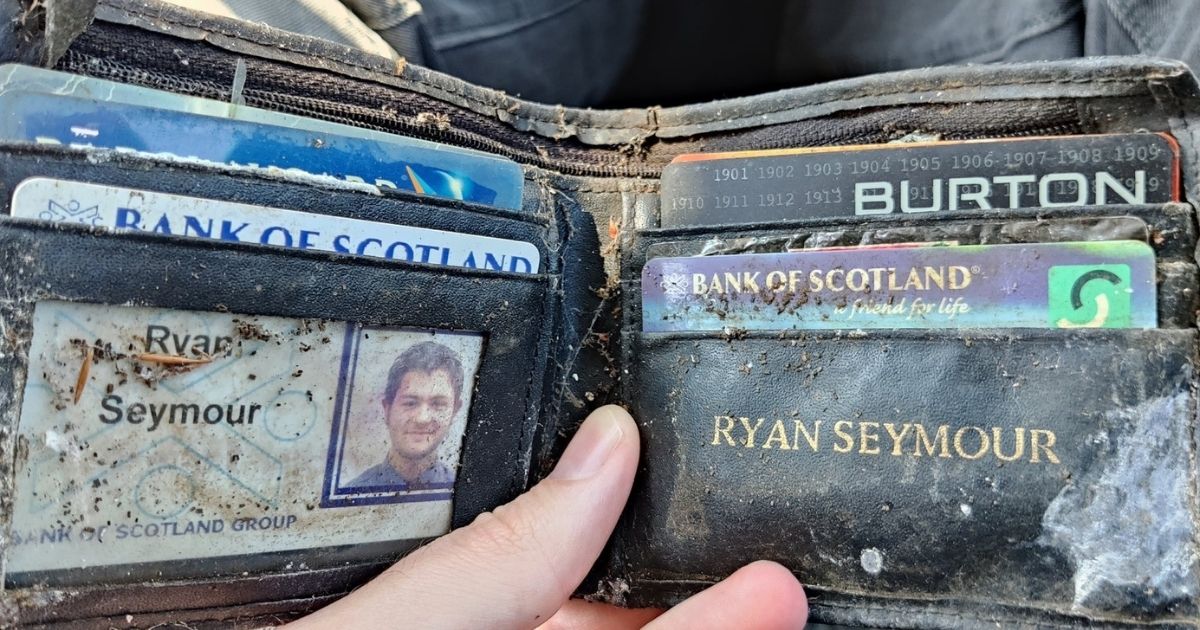 Ryan Seymour holding his old wallet, which had been stolen and thrown into a bush where it stayed for nearly 20 years before finding its way back to him.