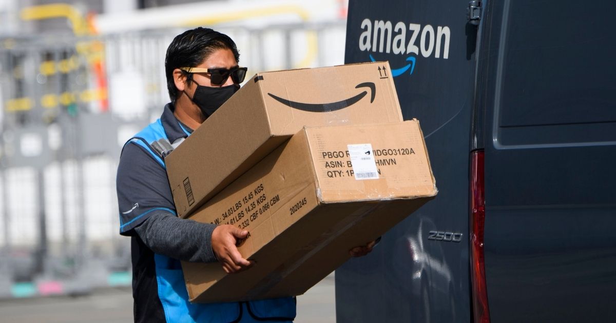 An Amazon.com Inc. delivery driver carries boxes into a van outside of a distribution facility on Feb. 2, 2021, in Hawthorne, California.